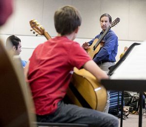 Brad Richter, a classical guitarist, speaks to student in a guitar class on Wednesday at Post Falls High School. This is the eleventh year Richter has met with high school students in the area, helping them with guitar techniques and offering inspiration. (Jake Parrish/Coeur d'Alene Press)