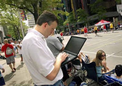 
Brian Town checks the downtown Spokane Hot Zone wireless area to see how his team is doing during Hoopfest last summer. 
 (File/ / The Spokesman-Review)