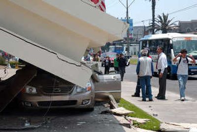 
A roof collapsed, crushing this car  in Antofagasta, Chile,  when an estimated 7.7-magnitude earthquake struck Wednesday. Associated Press
 (Associated Press / The Spokesman-Review)