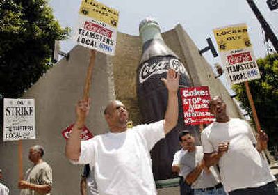 
David Miles, left, a quality-control technician, and Kevin Sauldsberry, right, a lift driver, along with fellow workers who are locked out of a Coca-Cola bottling plant, protest Monday in Los Angeles. More than 2,000 workers at plants in California and Connecticut went on strike Monday, just before the start of the summer soft drink season. 
 (Associated Press / The Spokesman-Review)