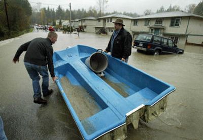 
Eddie Wadsack, left, moves his boat to help rescue people Monday in Granite Falls, Wash., as Loren Tonsgard helps. 
 (Associated Press / The Spokesman-Review)