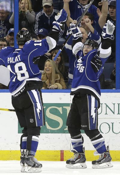 Tampa Bay center Tyler Johnson, right, celebrates after completing the first hat trick of his NHL career. (Associated Press)