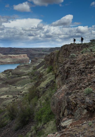 Photo of the week: Under blue spring skies, hikers trek along the lush and rocky perimeter of Deep Lake in the Sun Lakes-Dry Falls State Park in Grant County.