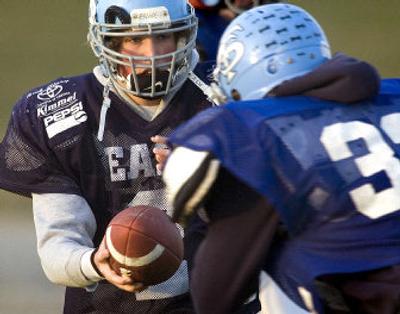 
Freeman High School quarterback Andrew Dresback hands off the ball to a running back during practice. Dresback injured  his shoulder but continues to be productive. 
 (Joe Barrentine / The Spokesman-Review)