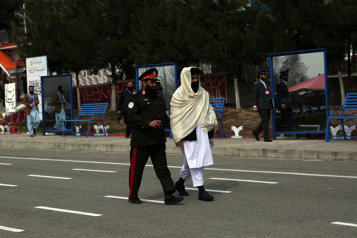 Taliban acting Interior Minister Sirajuddin Haqqani, right, reviews new Afghan police recruits during a graduation ceremony at the police academy in Kabul, Afghanistan, Saturday, March 5, 2022. Taliban acting Interior Minister Sirajuddin Haqqani, a designated terrorist by the U.S., said fighters guilty of "misconduct" were being penalized after a string of abuse allegations, in a rare public appearance on Saturday. (STR)