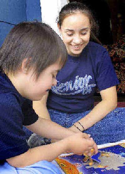 
Trisha Samuels, 18, helps her brother Matthew, 7, with his puzzle.
 (Kandis Carper / The Spokesman-Review)