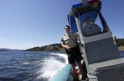 
Kootenai County Sheriff's Deputy Travis Smith, left, and Dustin Repp turn toward some boaters whose boat had broken down Friday afternoon in Wolf Lodge Bay on Lake Coeur d'Alene. 
 (Jesse Tinsley / The Spokesman-Review)