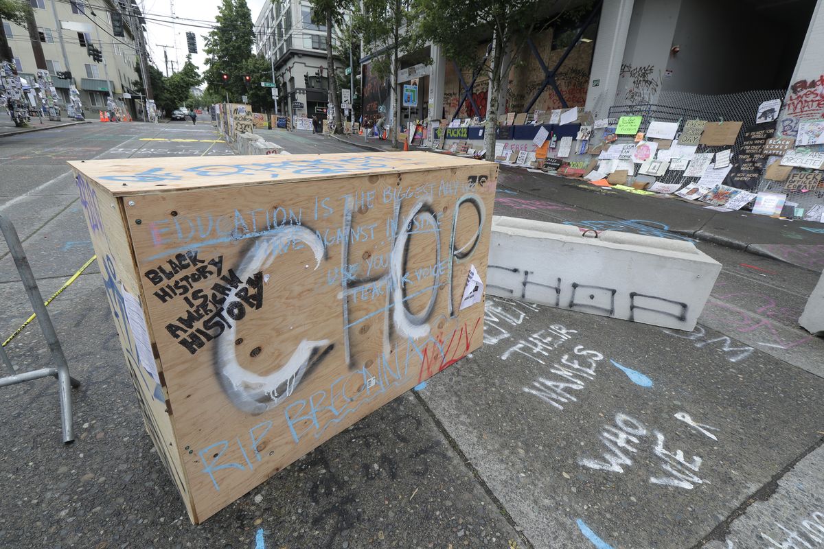 CHOP is spray painted on a barricade, Saturday, June 20, 2020, inside what has been named the Capitol Hill Occupied Protest zone in Seattle. A pre-dawn shooting near the area left one person dead and critically injured another person, authorities said Saturday. The area has been occupied by protesters after Seattle Police pulled back from several blocks of the city