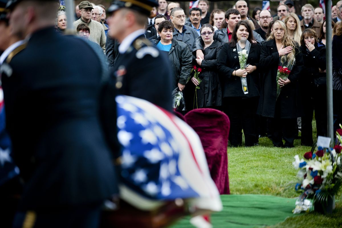 Friends and family of Army Staff Sgt. Matthew H. Stiltz watch in sorrow as his casket is carried to his burial site on Saturday at Greenwood Cemetery in Spokane. (PHOTOS BY TYLER TJOMSLAND)