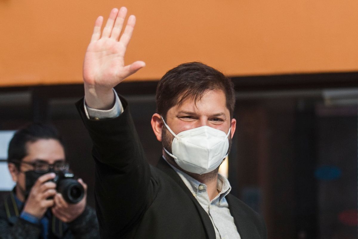 Presidential candidate Gabriel Boric, of the "I approve Dignity" coalition, waves to supporters at a polling station during the presidential run-off election in Punta Arenas, Chile, Sunday, Dec. 19, 2021.  (Andres Poblete)