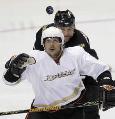Anaheim forward Teemu Selanne reaches for a loose puck as Dallas defenseman Mattias Norstrom closes in. Associated Press
(Associated Press / The Spokesman-Review)