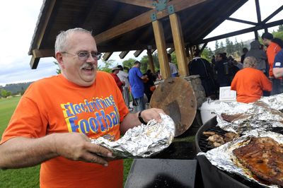 Spokane Shock booster club member John Austin lays rack after rack of smoked ribs and chicken on the grill at the monthly Spokane Shock booster club picnic Thursday.  (Jesse Tinsley / The Spokesman-Review)