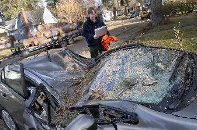 
Zach Hedgpeth was glad he was able to retrieve work-related items from his crushed Honda Civic Hybrid on Saturday after a crew from Arbor Care Tree Service of Spokane sectioned and removed a tree from his front yard at 26th and Tekoa that had blown down during Friday morning's windstorm. 
 (Dan Pelle / The Spokesman-Review)