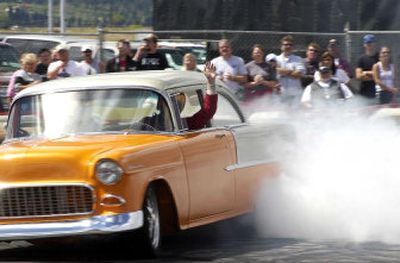 
A driver waves during the freestyle burn out competition at Post Falls' River City Rod Run Saturday. 
 (Tom Davenport/ / The Spokesman-Review)