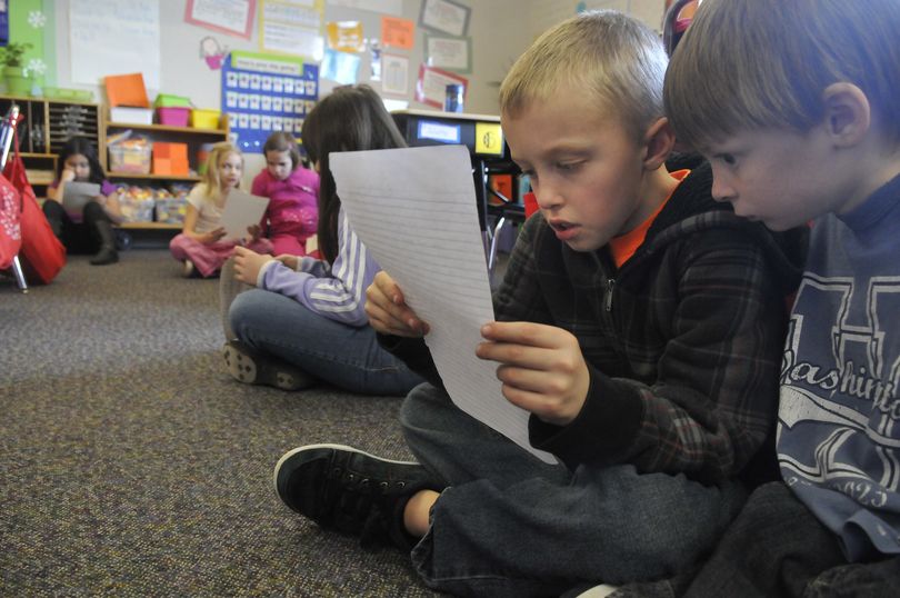 Liam Kennedy, left, and Jaden Conwell, both 8 years old and third-graders at Adams Elementary, read pen pal letters from schoolchildren in Ghana, Wednesday. The most recent letters included talk of Christmas activities. (Jesse Tinsley)