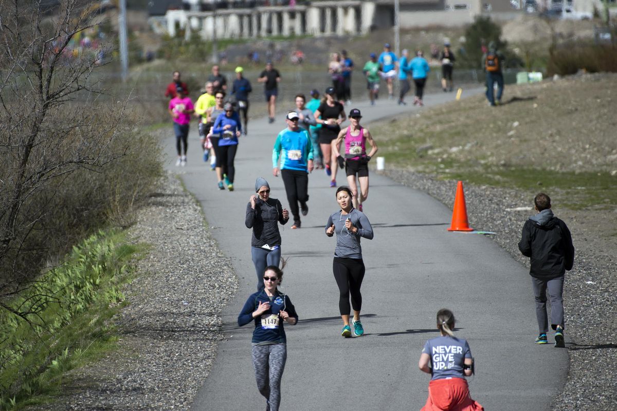 Hundreds of runners participating in the Negative Split road race work their way out and back along the Centennial Trail in the Kendall Yards development on Sunday, April 9, 2017. A device installed along the trail has counted 330,000 trail users in over a year and a half. (Jesse Tinsley / The Spokesman-Review)