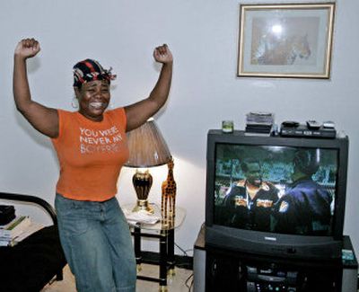 
Mitina Burnett, of Wellston, Mo., celebrates in her living room after her electrical power was restored Tuesday. Thunderstorms hit the St. Louis area last week, downing trees and power lines.
 (Associated Press / The Spokesman-Review)