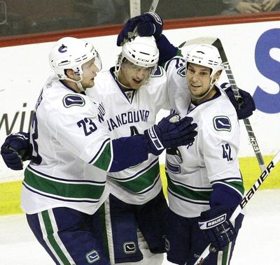 Vancouver Canucks right wing Michael Grabner (center), a former Spokane Chief, is congratulated for his first NHL goal.  (Associated Press / The Spokesman-Review)
