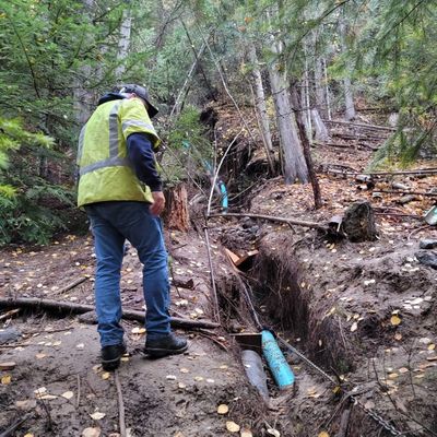 A worker stands next to an exposed area of the temporary water line repair following the bursting of the original main.  (Photo Courtesy of Pend Oreille Public Utilities Department)