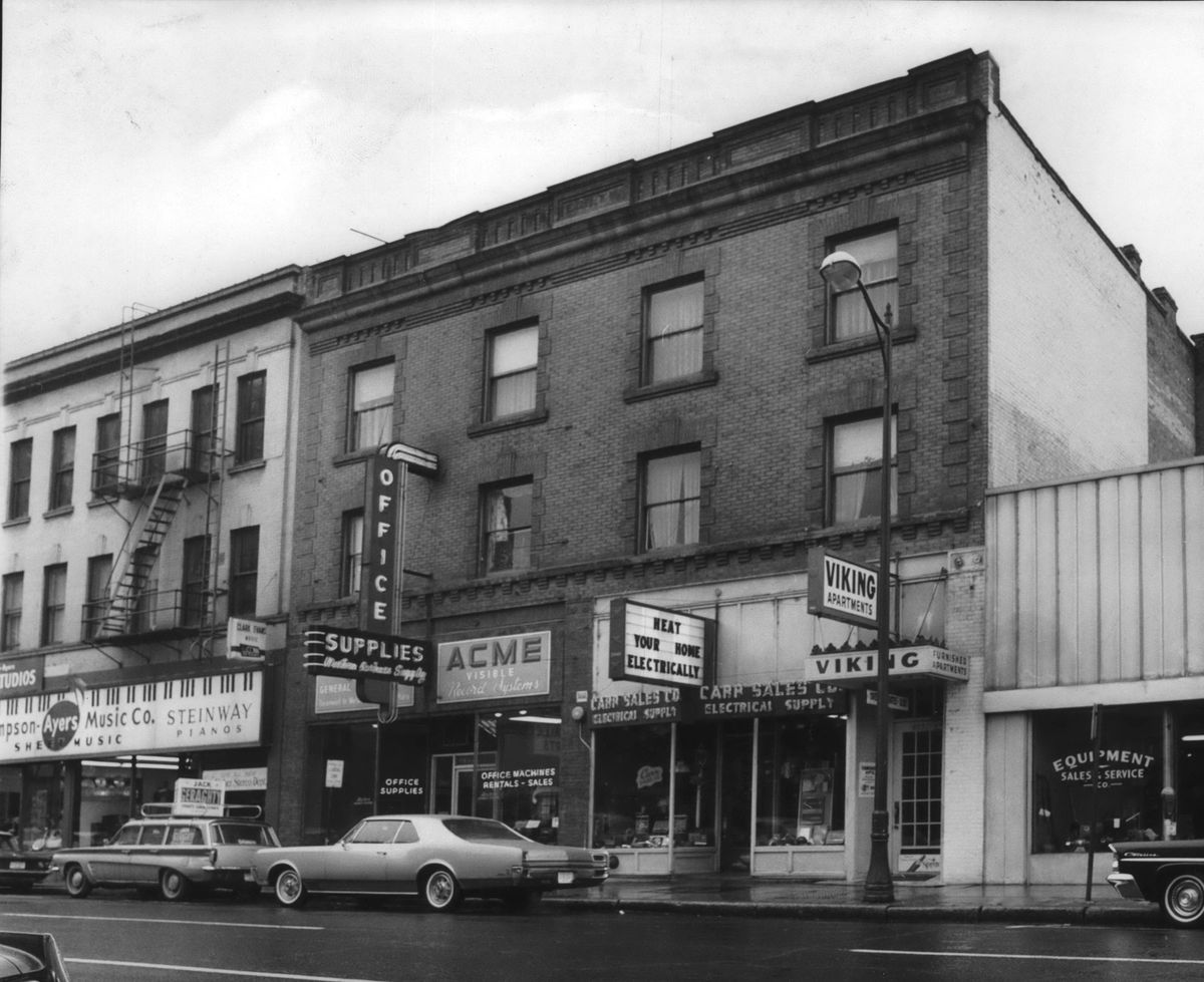 1964 - The modest three story building at 919 W. First Ave., center, was where Robert Carr founded his hardware business in 1929. The business was purchased by Don Barnett in 1946, transformed into an electrical supply business that still exists there today. In 1964, the date of this photo, Barnett purchased the building and later expanded into 915 W. First Ave., seen at left, in the 1980s. The 915 building started as a seed store and around 1929, became Ruth Sampson Sheet Music, later Sampson-ayers House of Music, a run of 50 years for the music store. (Spokesman-Review archive)