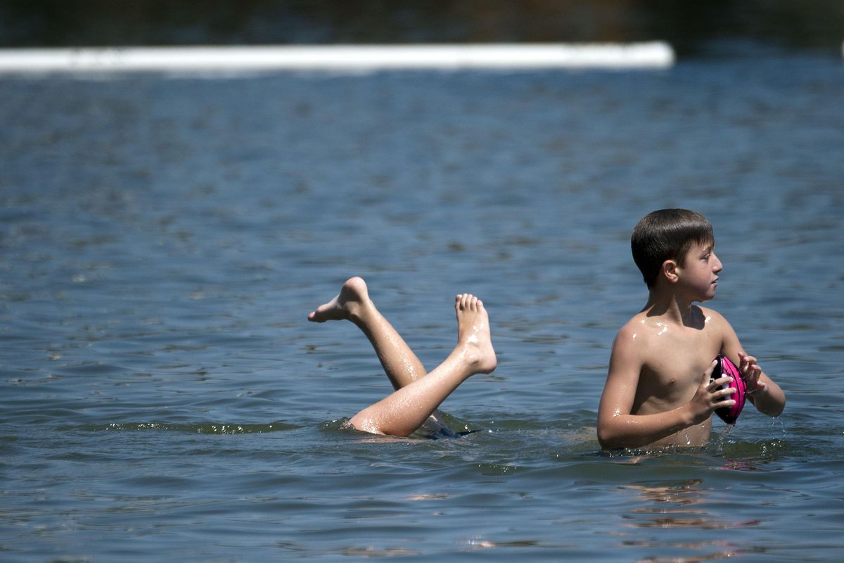 Ten-year-old Caleb Linder, left of Colbert does a hand-stand as his cousin Gavin Witte, 9, of Mead stay cool in the Spokane River at Q