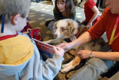 
A therapy dog named Ginger is the center of attention at the Coeur d'Alene Library,  where Bryan Pesikan, 7, left, shows the dog a picture book. Ginger's handler is Sheila Darsie, right. At top is Phoebe Felker, 8. 
 (Jesse Tinsley / The Spokesman-Review)