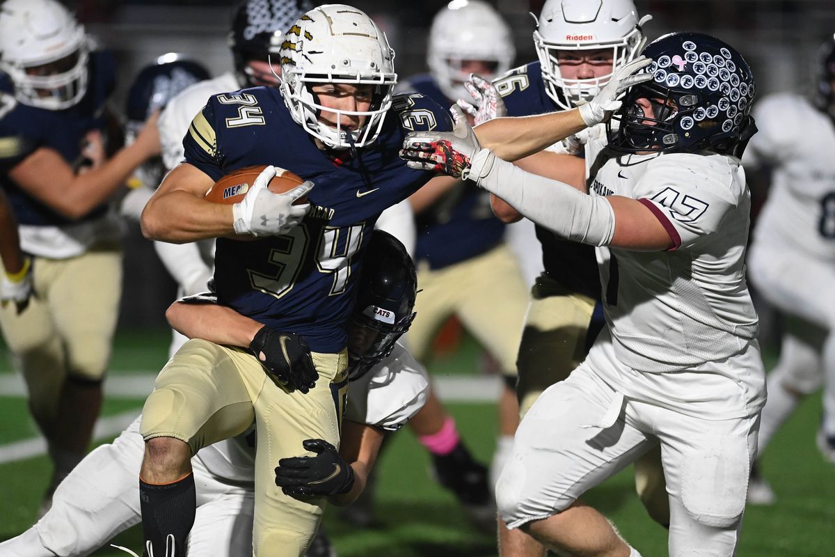 Mead running back Schuyler Harkness (34) runs the ball for a 5-yard gain as Mt. Spokane linebacker Jackson Kink (47) tries to tackle during a GSL high school football game, Friday, Oct. 15, 2021, in Union Stadium in Mead, Wash.  (Colin Mulvany/THE SPOKESMAN-REVIEW)