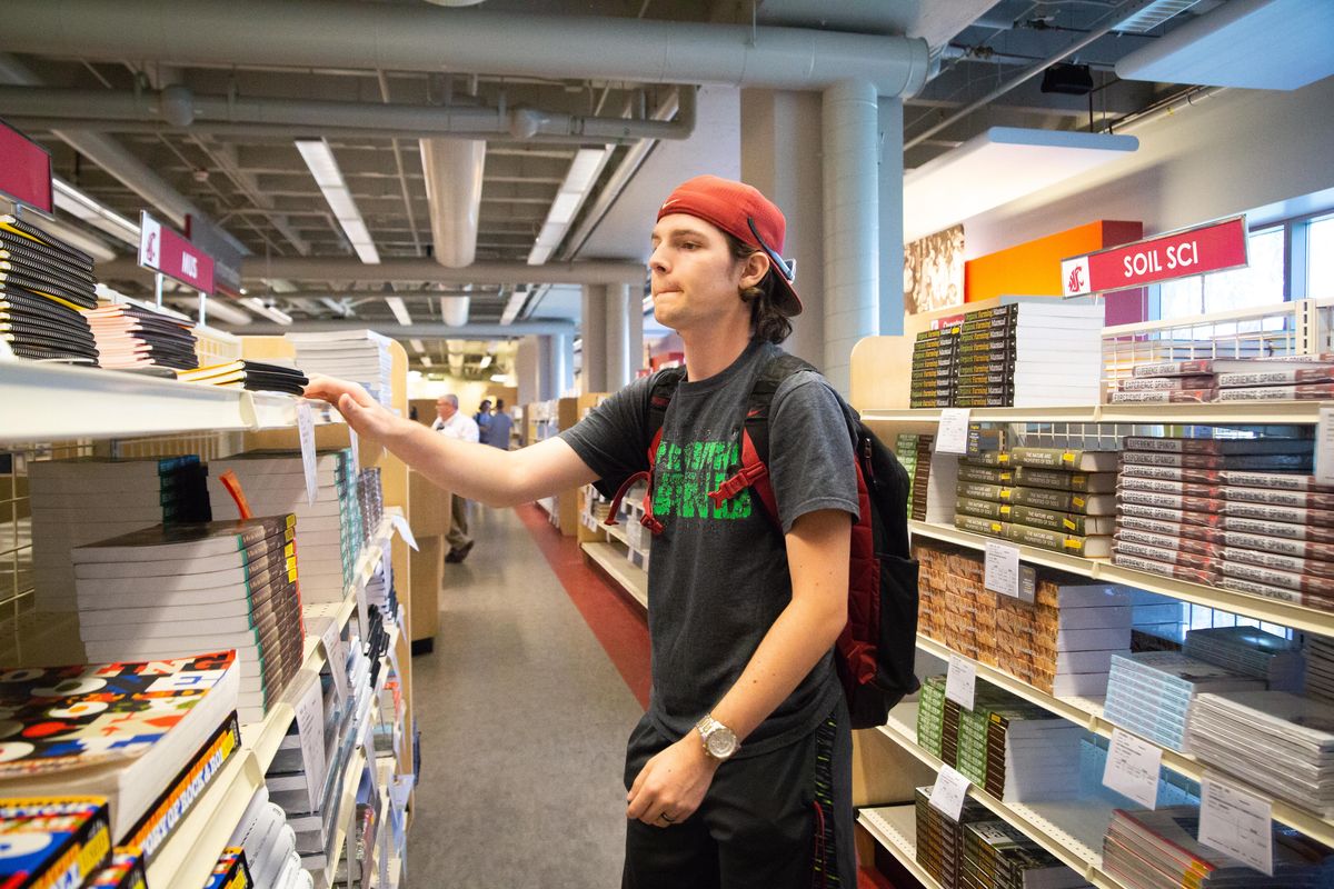Sophomore Riley Hoover looks for textbooks required for his new classes in the Compton Union Building on the Washington State University main campus in Pullman, Wash. on Monday, Aug. 19, 2019. (Libby Kamrowski / The Spokesman-Review)