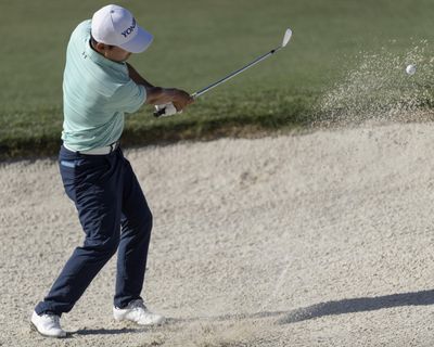 Sung Kang hits a bunker shot on 18 during second round of the Shell Houston Open on Friday. Kang shot a 63 and leads by six strokes. (Wilf Thorne / Associated Press)