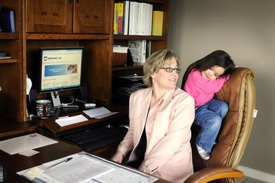 Mindy Stewart, co-owner of KidCentric Inc., works from her home office in Newman Lake, where she is sometimes interrupted by Abigail, 3, the youngest of her three daughters. KidCentric consults with companies about onsite daycare, then opens and operates the daycare facility if the company wishes.  (Jesse Tinsley / The Spokesman-Review)