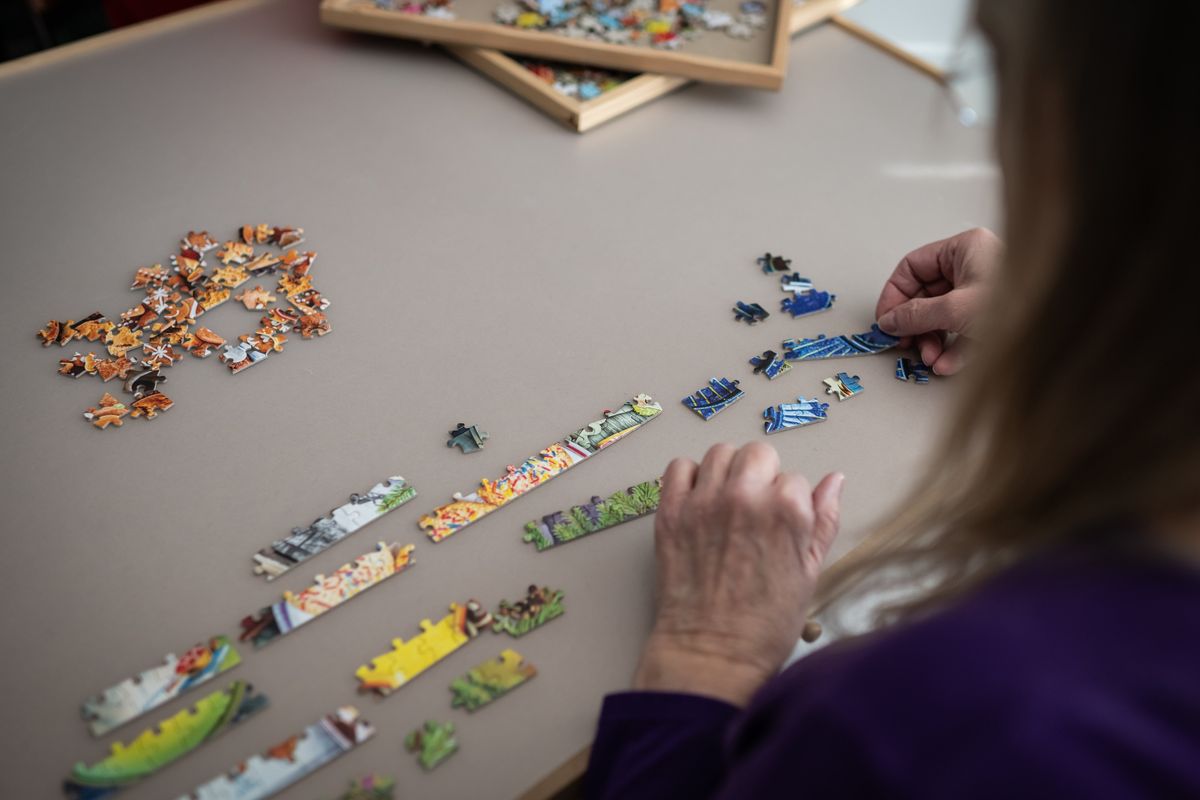 Linda Groskreutz starts putting together a puzzle in her basement. To begin, she sorts pieces by color and puts pieces of the edges together. MUST CREDIT: Caroline Yang/For The Washington Post  (Caroline Yang/For The Washington Post)