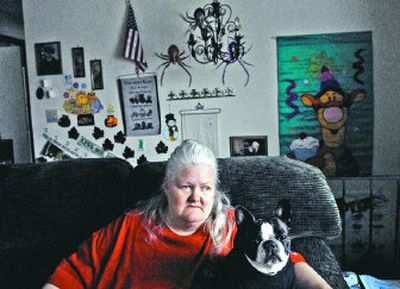 
Cari Elmore, of Coeur d'Alene, sits on her couch with her dog, Rebecca Lynn, on Thursday. Her cat, Thomas, was recently killed by pit bulls, and she wants the breed banned from Coeur d'Alene. 
 (The Spokesman-Review)