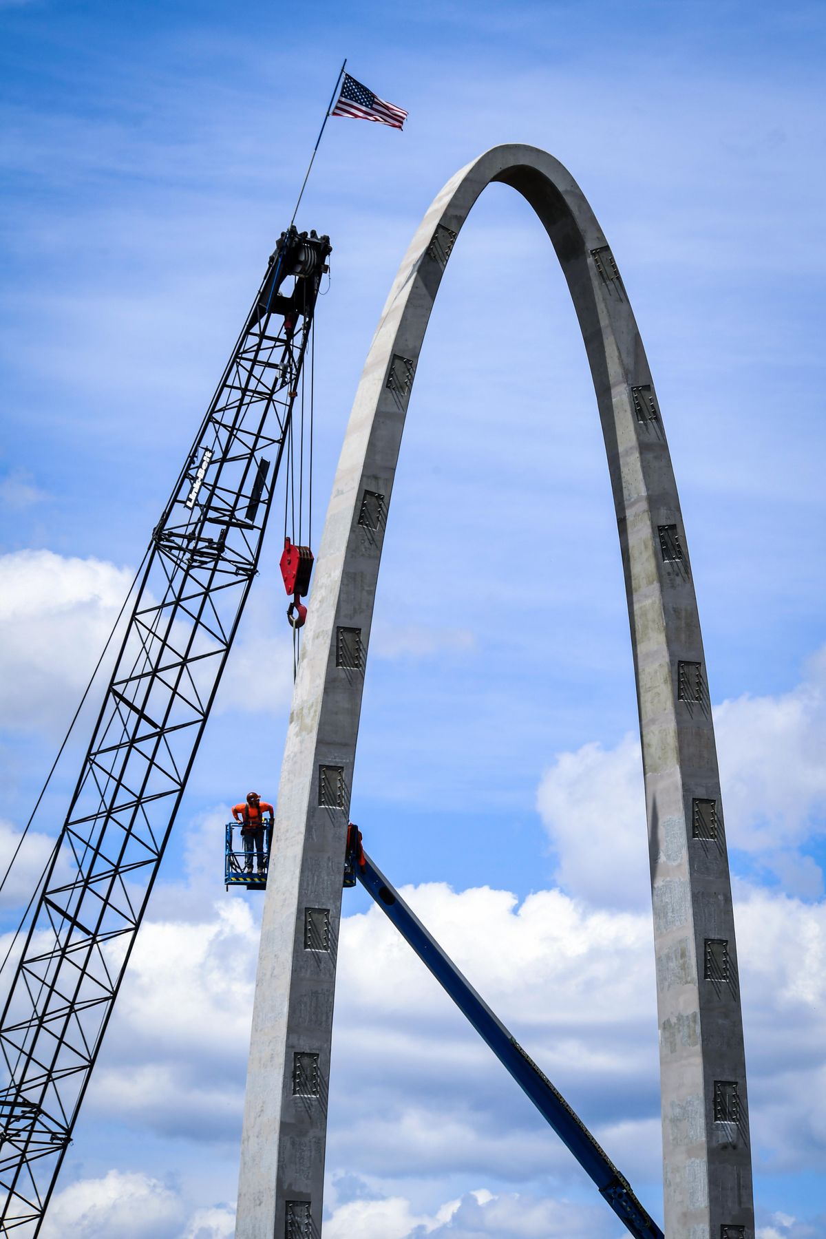 A worker views the newly-completed arch of the University District Gateway Bridge on Wednesday, May 30, 2018 in Spokane. (Dan Pelle / The Spokesman-Review)