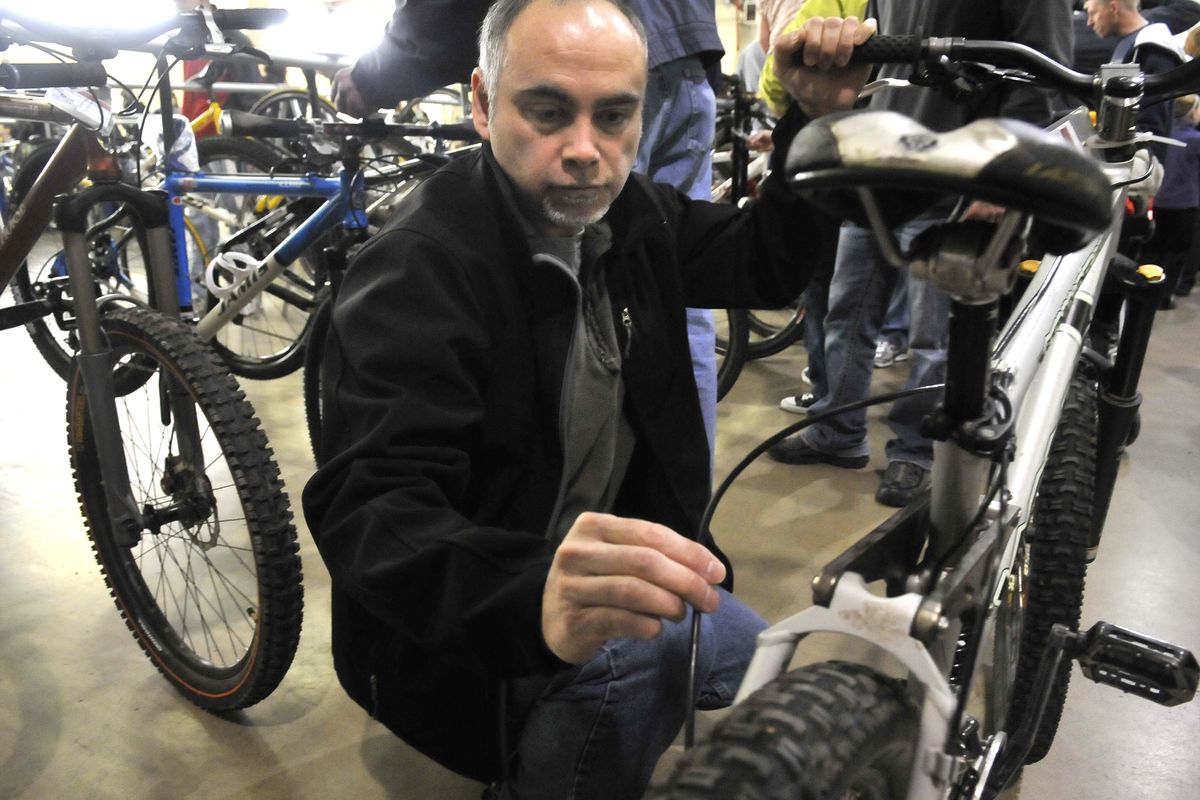 Greg Morley, of Spokane, examines a high-end mountain bike he chose from the racks of consignment bikes available Saturday at the Spokane Fair and Expo Center. The Spokane Bike Swap, which organizers hope will be an annual event, concludes today. (Jesse Tinsley)