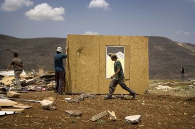Jewish settlers try to rebuild a structure demolished earlier by Israeli troops in the West Bank outpost of Maoz Esther on Thursday.  (Associated Press / The Spokesman-Review)