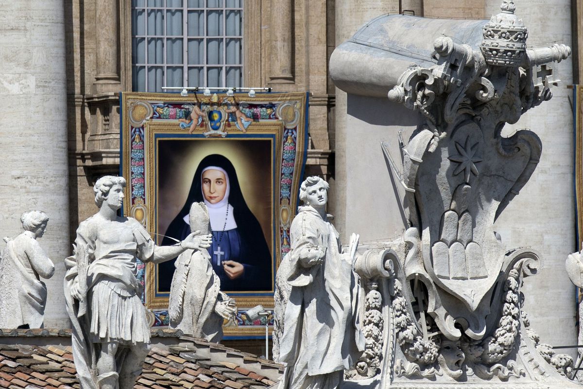 A tapestry showing St. Marie Alphonsine Ghattas hangs from a balcony of St. Peter’s Basilica at the Vatican, Sunday. (Associated Press)