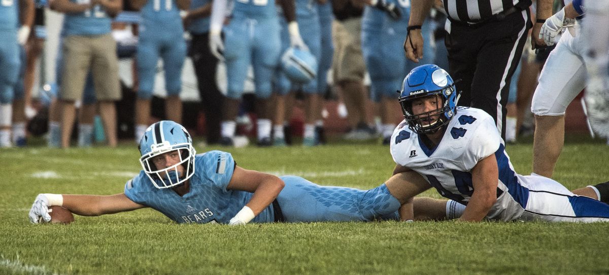 Central Valley WR Austin Tomlinson looks for a first down against Coeur d’Alene LB Noah Throm (44), Sept. 1, 2017, in Spokane Valley, Wash. (Dan Pelle / The Spokesman-Review)