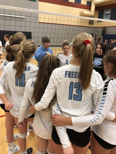 Freeman coach Eva Windlin-Jansen (blue sweatshirt) huddles with the team during Tuesday’s Northeast A League volleyball match with Riverside. The Scotties won in three games, 25-10, 25-17, 25-13. (Steve Christilaw / The Spokesman-Review)