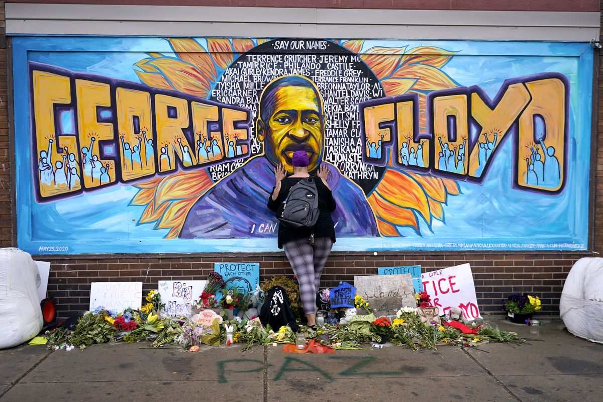 Damarra Atkins pays respect to George Floyd at a mural at George Floyd Square on Friday in Minneapolis.  (Julio Cortez/Associated Press)