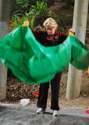 OLYMPIA -- Gov. Chris Gregoire practices opening and covering herself with a fire shelter  Tuesday at a training session with the Department of Natural Resources. The training session is necessary for being on site at a wildfire or forest fire. (Jim Camden/The Spokesman-Review)