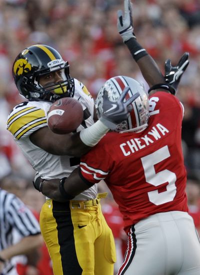 OSU’s Chimdi Chekwa deflects pass intended for Iowa’s Derrell Johnson-Koulianos.  (Associated Press)