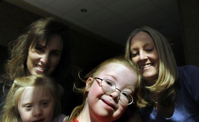 Three-year-old Emma Villelli, front, and 6-year-old Marissa Roberts are shown with their mothers, Cheryl Roberts, back left and Susan Villelli, at the Coeur d’Alene Library on April 10. Cheryl Roberts and Susan Villelli have started an organization for friends and families who have children with Down Syndrome.  (Kathy Plonka / The Spokesman-Review)