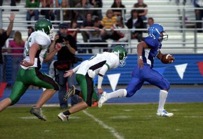 
Coeur d'Alene's Kevin Ah-Hi breaks free from East Valley's Jake Labelle, left and Jye Lanphere for the first of his three 50-plus-yard touchdown runs Friday night at Coeur d'Alene High School.
 (Tom Davenport/ / The Spokesman-Review)