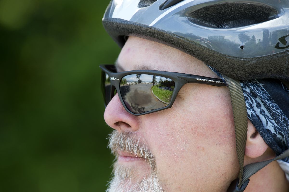 David Brown, the Cliff Drive overlook reflecting in his glasses, pauses to view the scenery during a bicycle ride Friday.