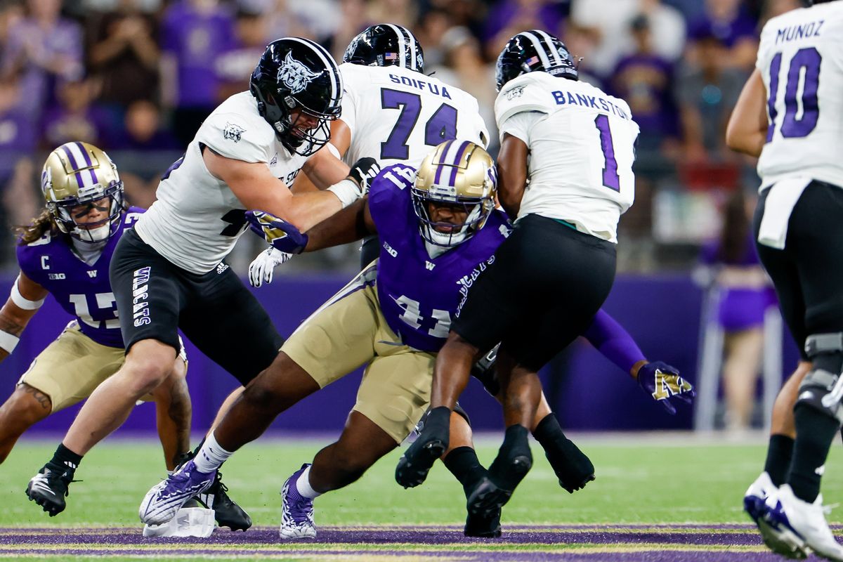 Washington Huskies defensive lineman Deshawn Lynch tackles Weber State Wildcats running back Damon Bankston during the first quarter Saturday, Aug. 31, 2024 in Seattle.   (Dean Rutz/Seattle Times)