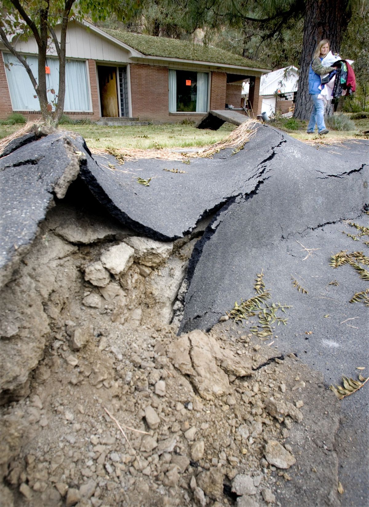 Rebecca Simmons removes personal belongings from her condemned home along Route 410 on Monday Oct. 12, 2009, after a massive landslide took out the state route west of Naches, Wash., over the weekend. Simmons