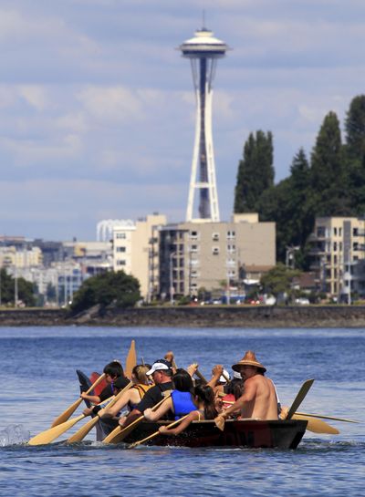 Tribal ritual: A tribal canoe is maneuvered into position after being welcomed by members of the Muckleshoot Tribe on their arrival Wednesday at Seattle’s Alki Beach. The landing of about a dozen canoes from the south was one leg of the annual journey of tribal canoes from throughout the Salish Sea, heading to Swinomish, Wash. About 100 tribal canoes are expected to arrive there on Monday. Go to spokesman.com/picture-stories for more photos. (Associated Press)