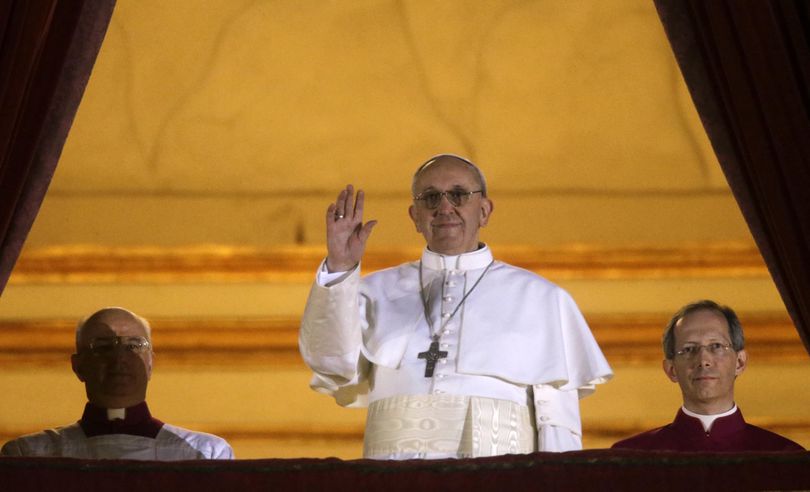 Pope Francis waves to the crowd from the central balcony of St. Peter's Basilica at the Vatican, Wednesday, March 13, 2013. Cardinal Jorge Bergoglio who chose the name of  Francis is the 266th pontiff of the Roman Catholic Church. (Gregorio Borgia / Associated Press)