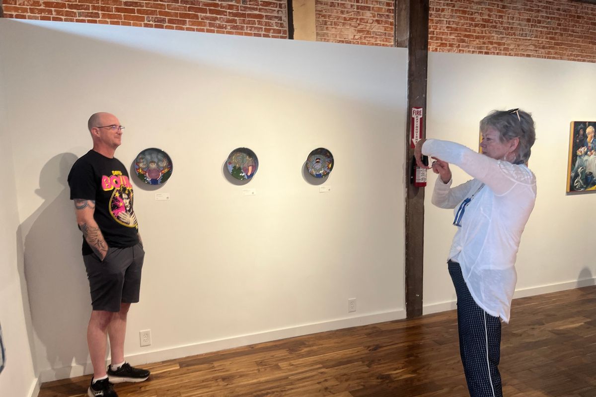 Lance Sinnema, left, poses with his glazed ceramic plates as Kay O