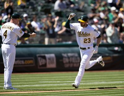 Oakland Athletics' Matt Joyce (23) gets a congratulatory fist bump from third base coach Matt Williams (4) after hitting a two-run home run against the Tampa Bay Rays during the eighth inning of a baseball game Thursday, May 31, 2018, in Oakland, Calif. The A's won 7-3. (D. Ross Cameron / AP)